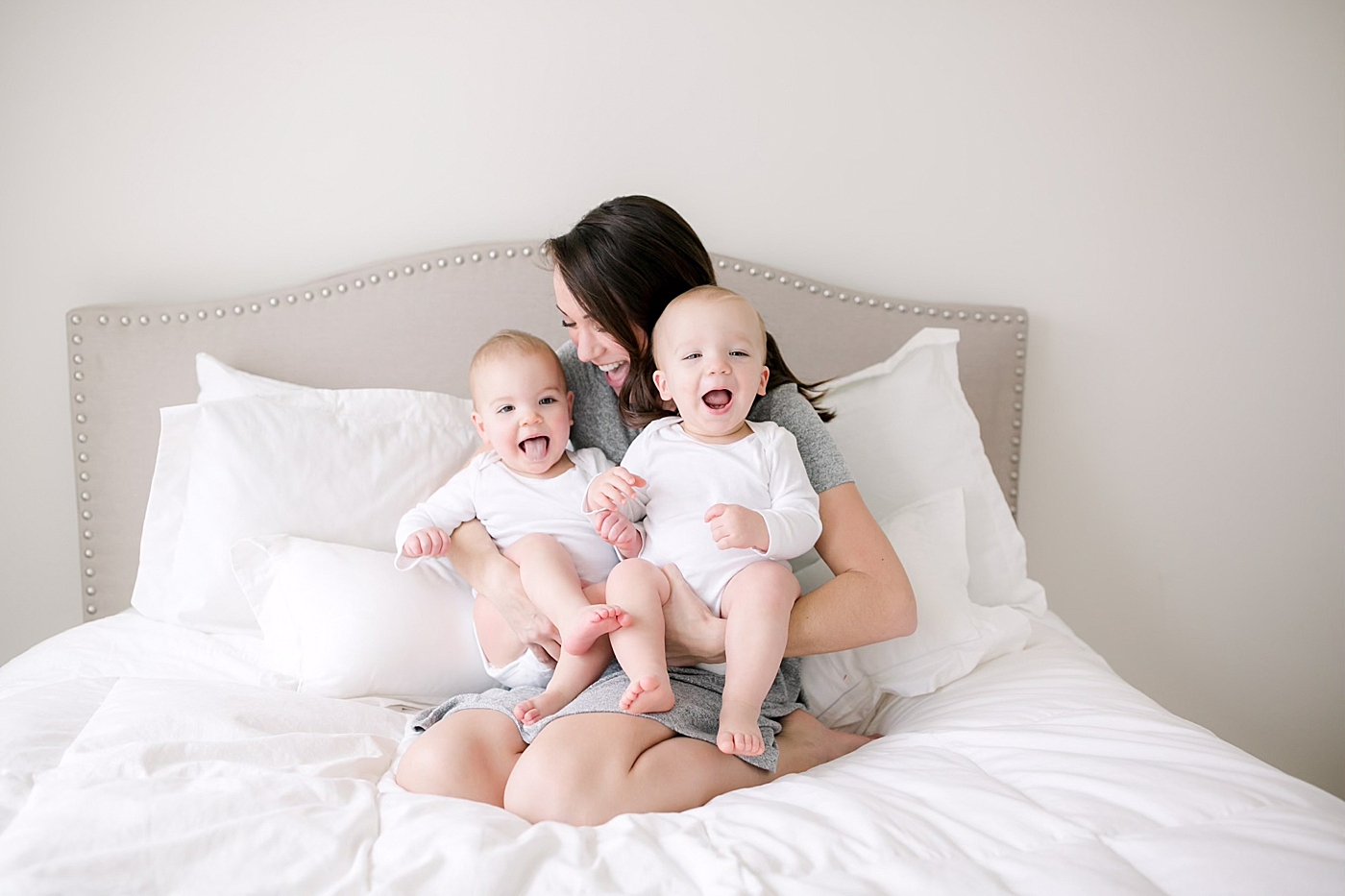 Mom snuggling with her twin babies | Image by Emily Gerald Photography